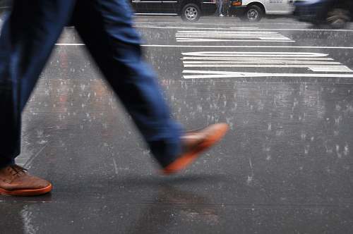 united states man wearing blue pants walking on street tarmac